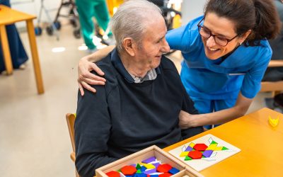 Senior man having fun with nurse playing board skill games in the geriatrics
